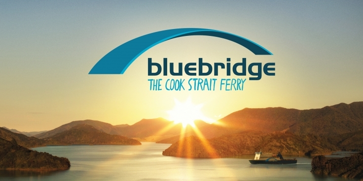 Bluebridge ferry passing through the Marlborough Sounds at sunrise with the company logo superimposed